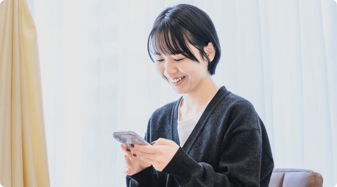 スマートフォンでWeb予約をする女性